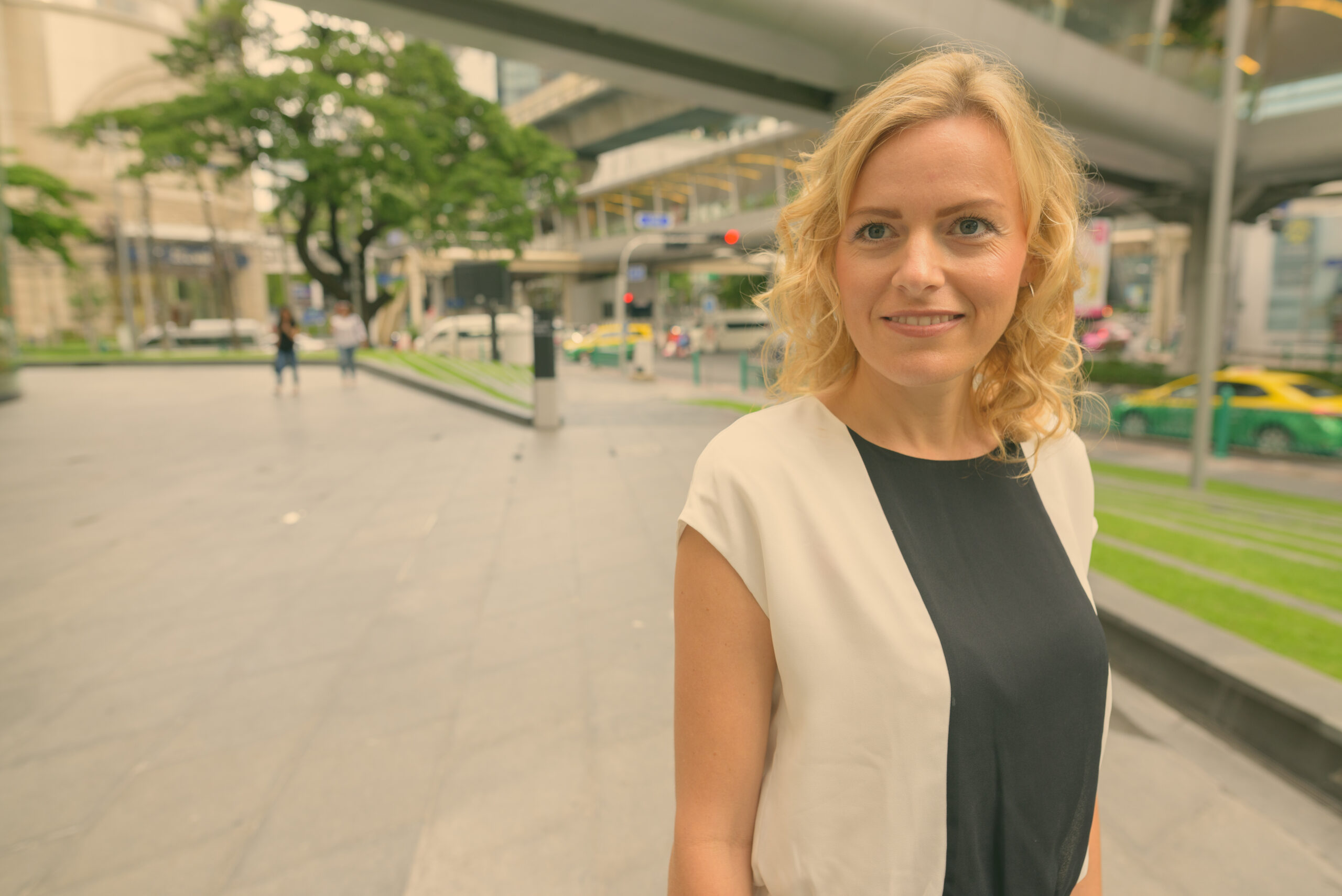 Portrait of beautiful blonde businesswoman exploring the city of Bangkok, Thailand
